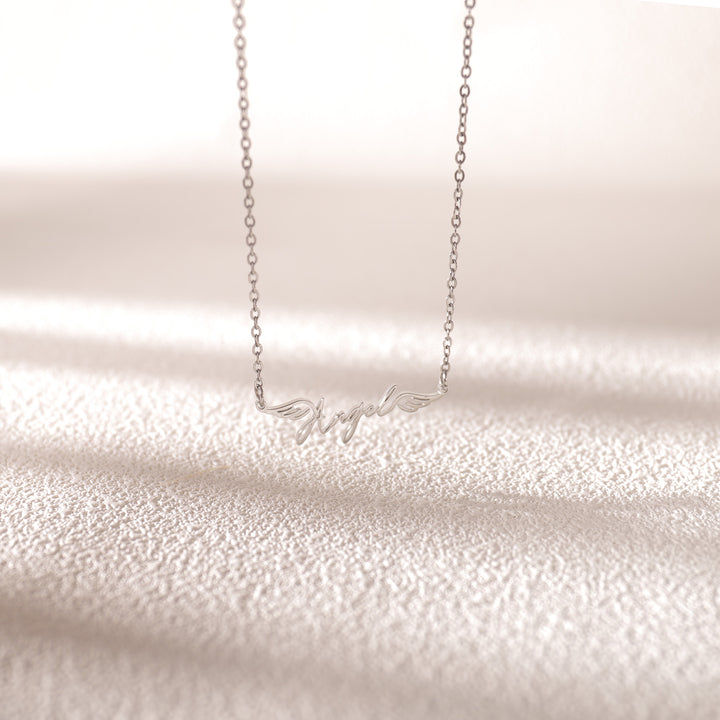 Silver cursive name necklace worn on model – delicate and timeless accessory